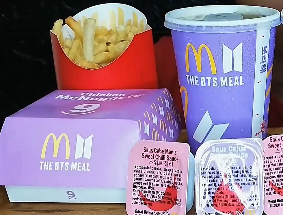 A "BTS Meal" served in Indonesia by McDonalds, as part of a collaboration with the South Korean boy band BTS. Clockwise from bottom left, this example contains 9 Chicken McNuggets, medium fries, a…