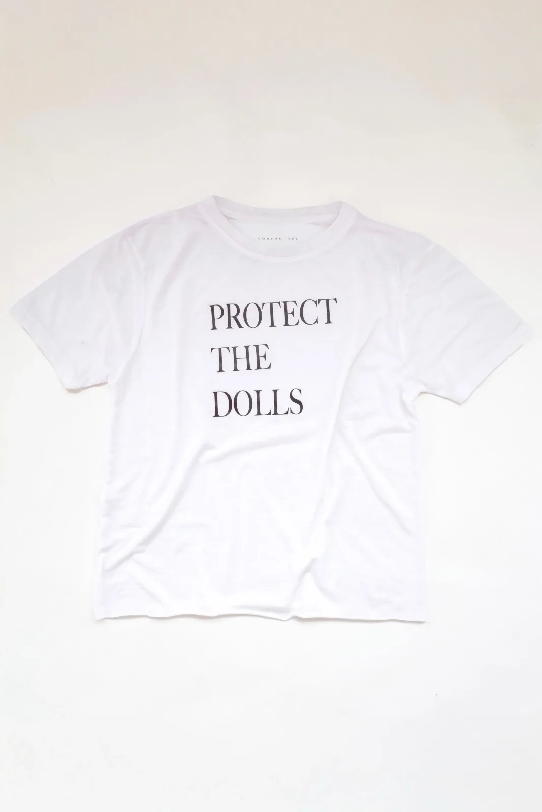 Original white Protect the Dolls shirt on Conner Ives’s official product page