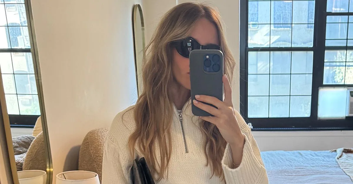 Nikki wears the j.crew tiny rollneck sweater in ivory with white jeans and a black clutch.