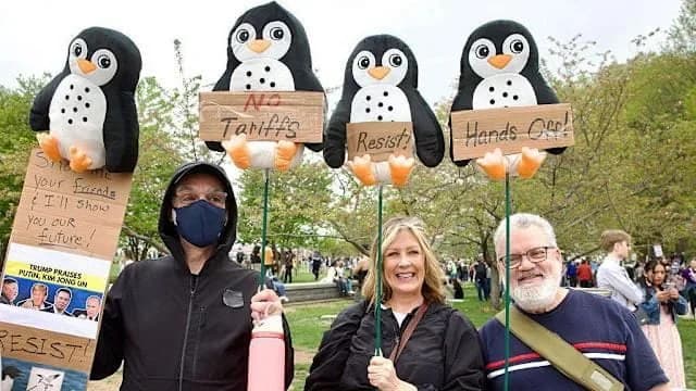 Protesters in Washington hold up penguin-themed signs