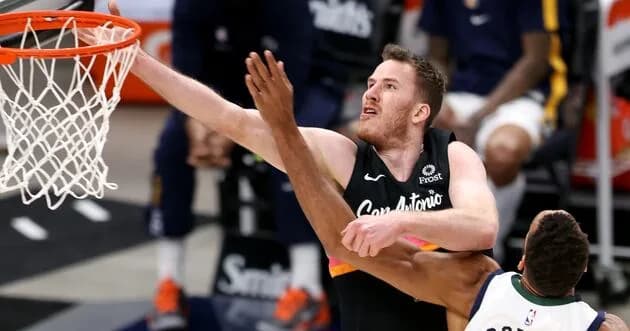 Former Utah Ute and current San Antonio Spurs center Jakob Poeltl (25) goes at Utah Jazz center Rudy Gobert (27) on a shot attempt as the Jazz and the Spurs play an NBA basketball game at Vivint…