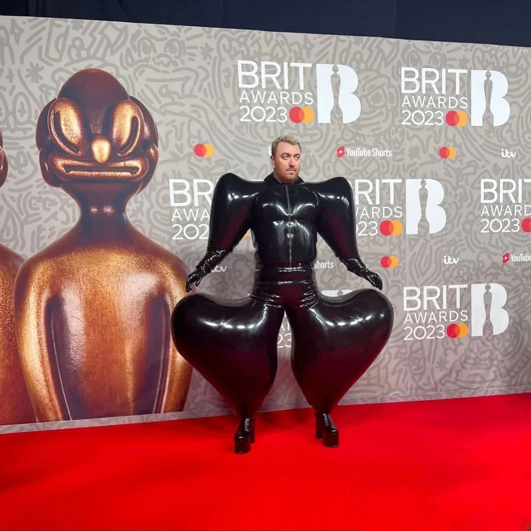 Sam Smith wearing the black inflatable latex suit on the BRIT Awards red carpet.
