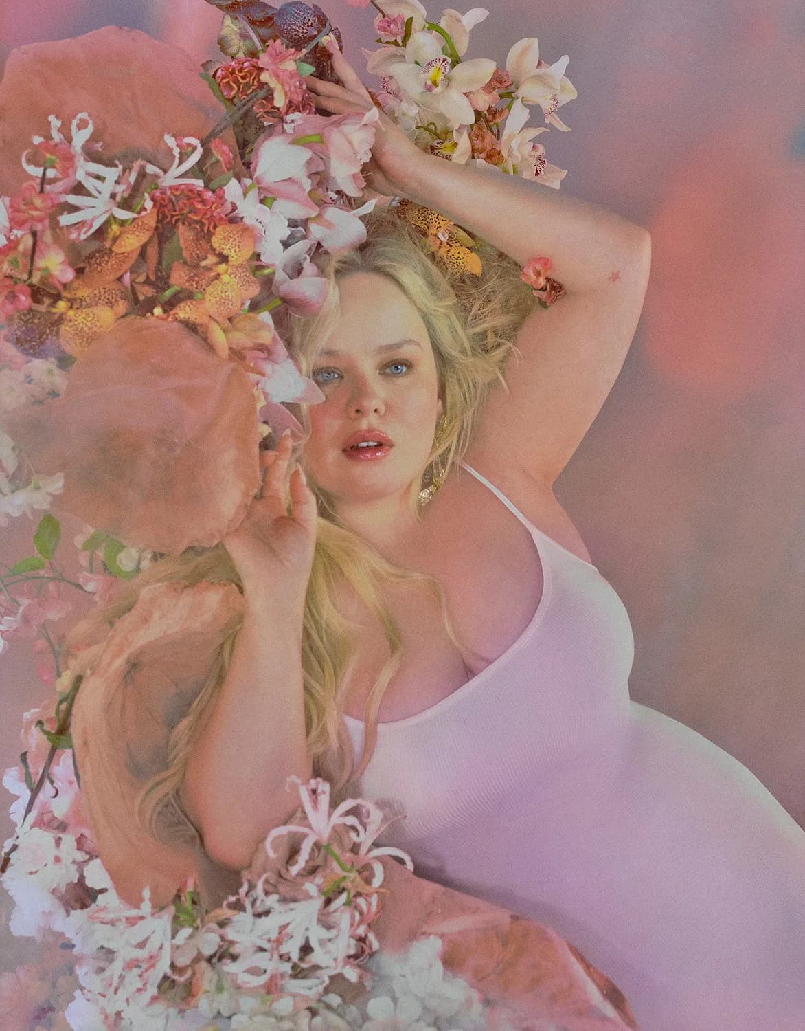 Nicola Coughlan wearing a white Soft Lounge slip dress amid flowers in the official campaign.