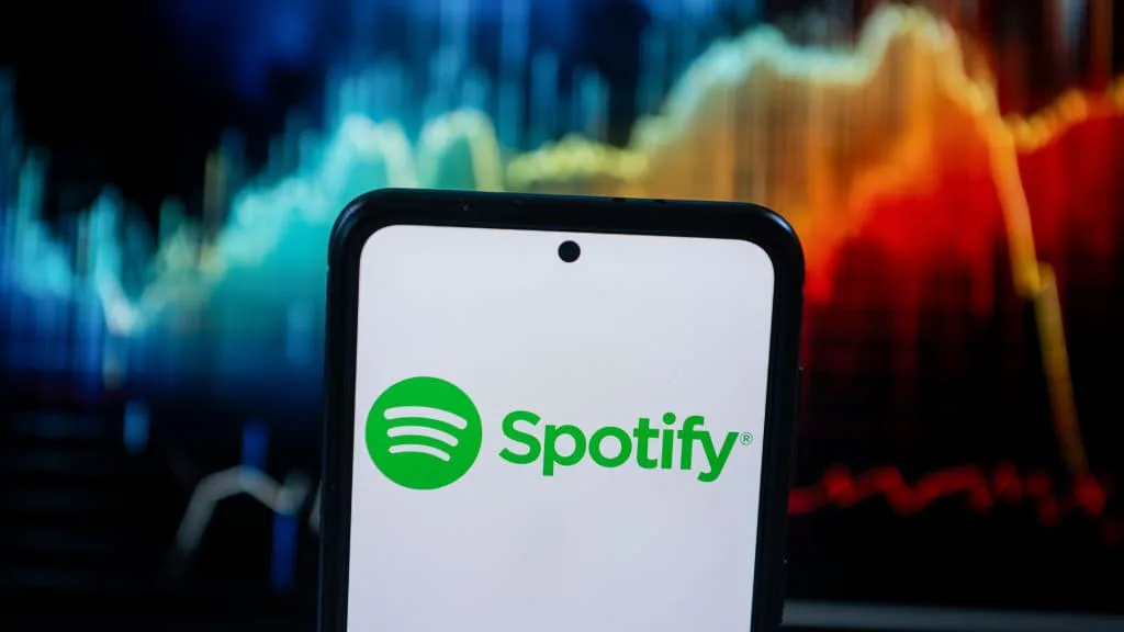 In this photo illustration a Spotify logo seen displayed on