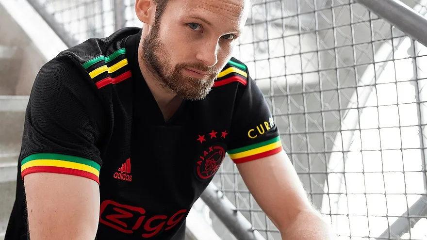 Daley Blind wearing the Ajax Bob Marley third kit in official launch photography.