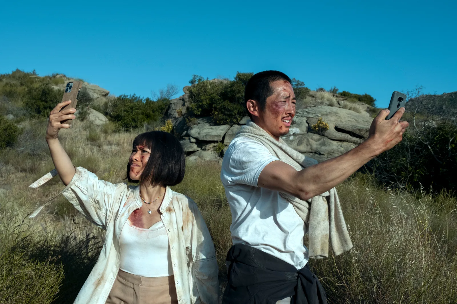 Ali Wong and Steven Yeun taking a selfie in a scene from Beef.