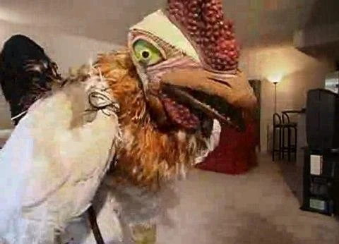 Subservient Chicken leaning toward the camera in its interactive living-room setting. 2004 campaign screenshot in a contemporary article later updated.
