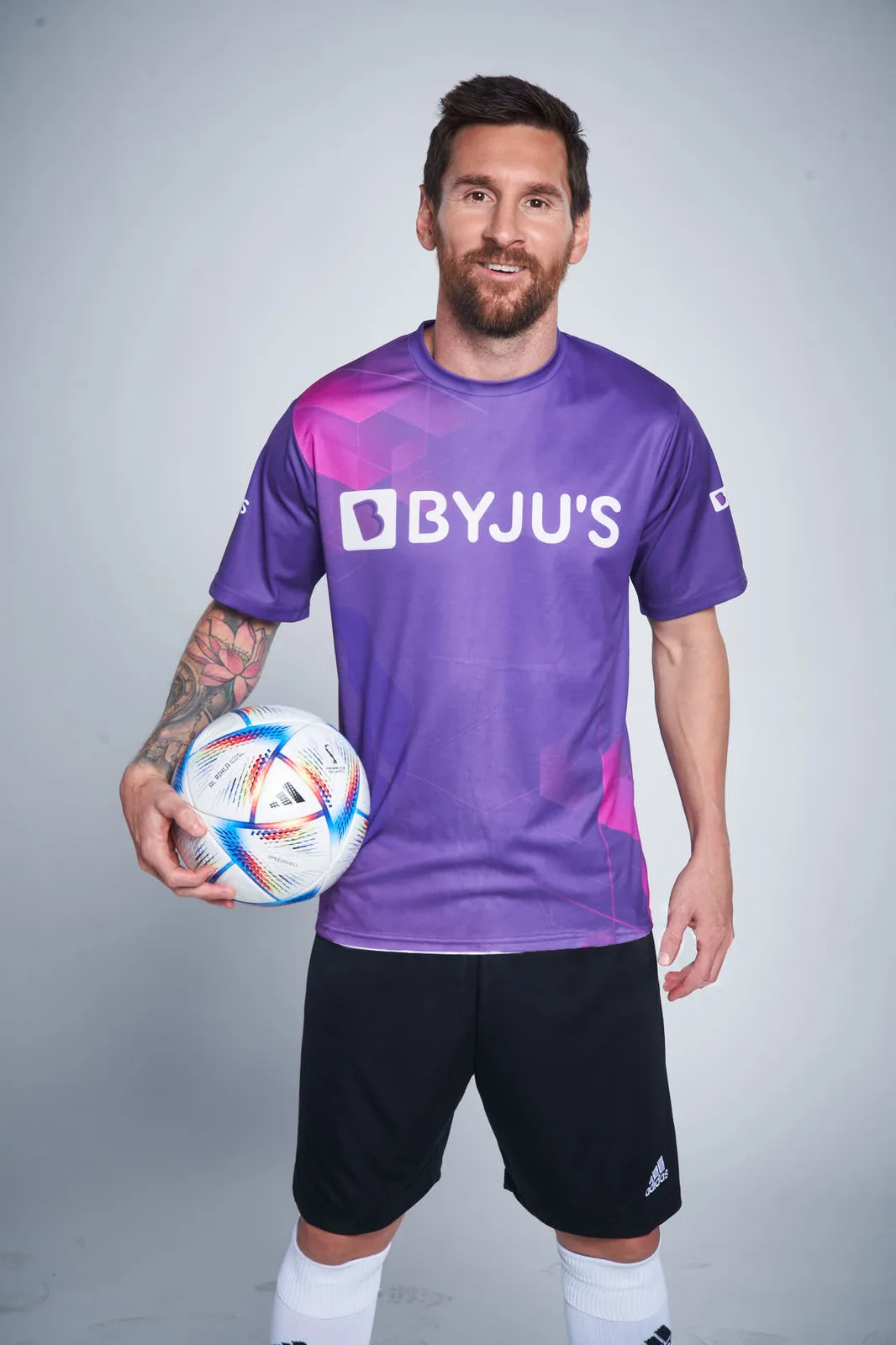 Official ambassador reveal photograph: Messi in a purple BYJU'S jersey holding a football.