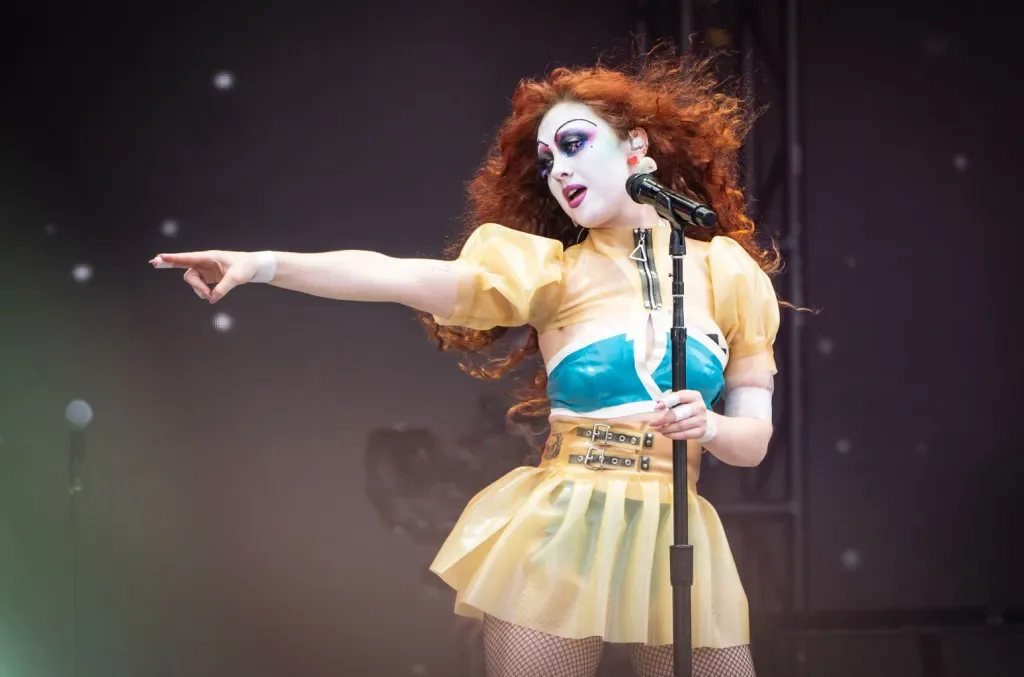 Chappell Roan pointing from the stage in a clown-inspired look
