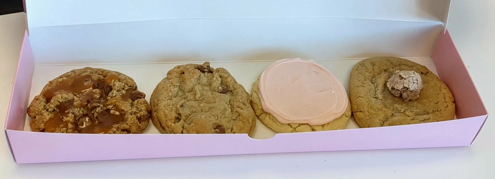 Cookies in an open Crumbl pink box.