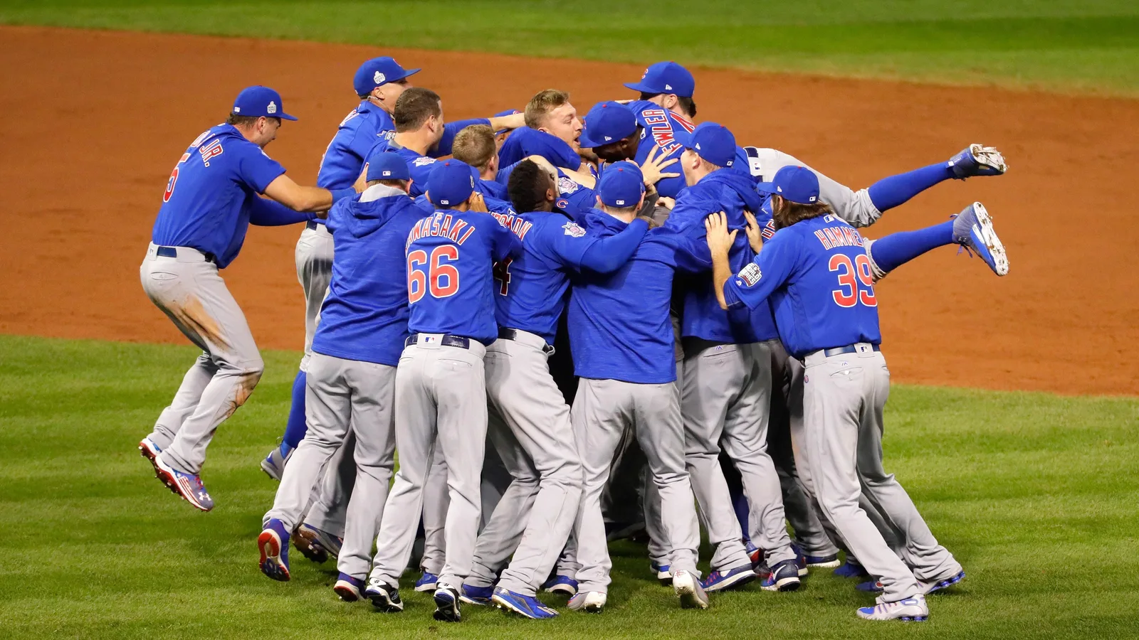 Cubs players pile up on the field after winning Game 7 in Cleveland