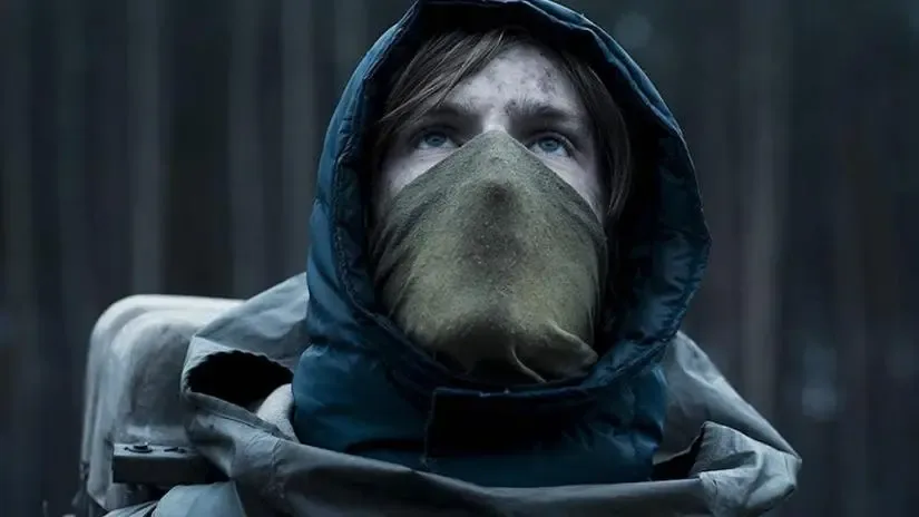 A figure in a hood and gas mask