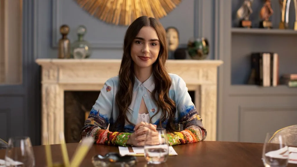 Lily Collins as Emily at a desk in a scene from Emily in Paris.