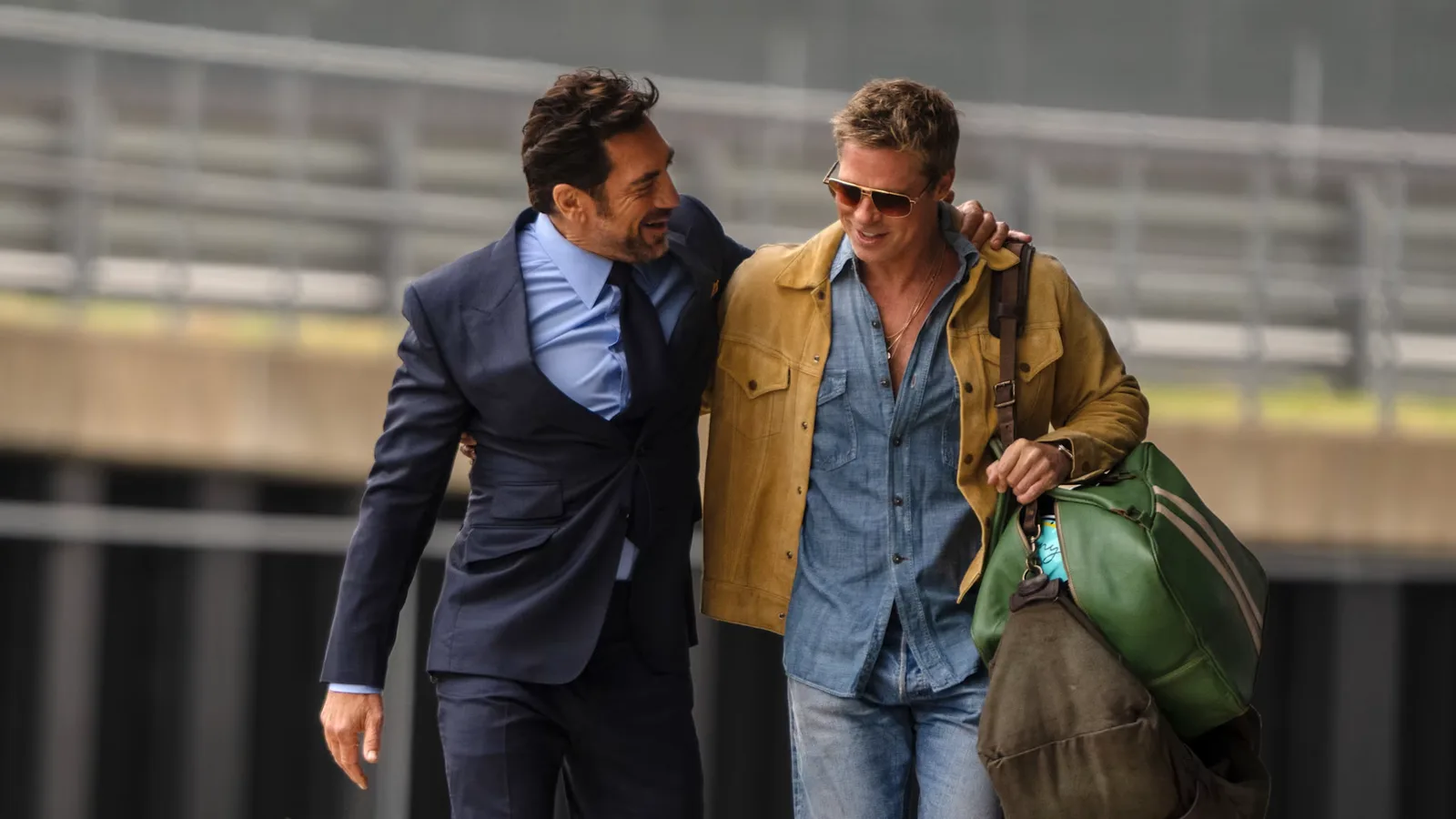 Javier Bardem and Brad Pitt walking a paddock in F1.