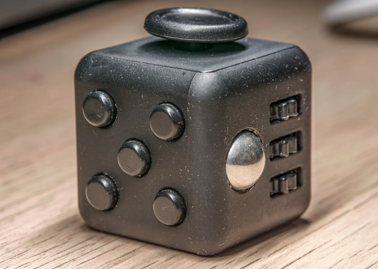 A black fidget cube photographed in 2021; Creative Commons Attribution 2.0. Brand authenticity is not established.
