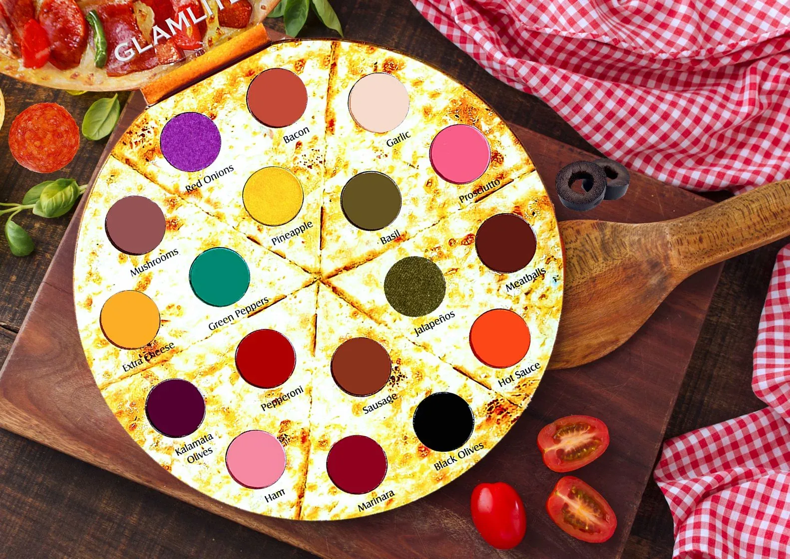 Open Glamlite Pizza Palette on a wooden board beside pizza toppings.