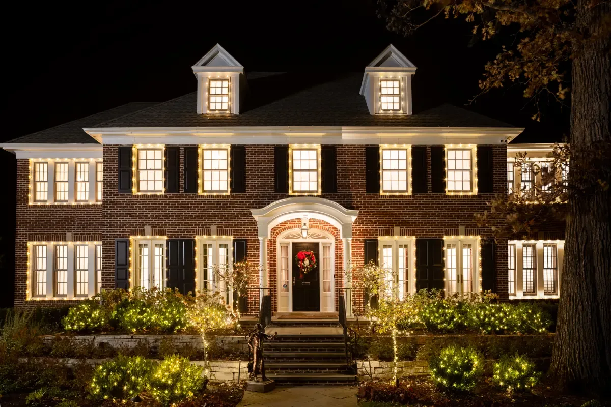 The Home Alone house lit up at night for the 2021 Airbnb stay