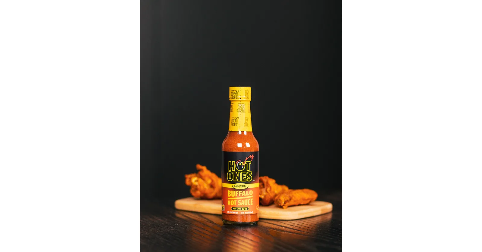 A Hot Ones hot sauce bottle with wings.