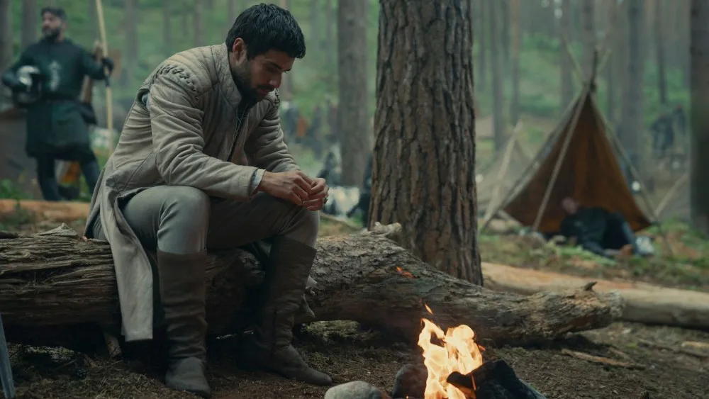 Fabien Frankel as Criston Cole by a campfire.