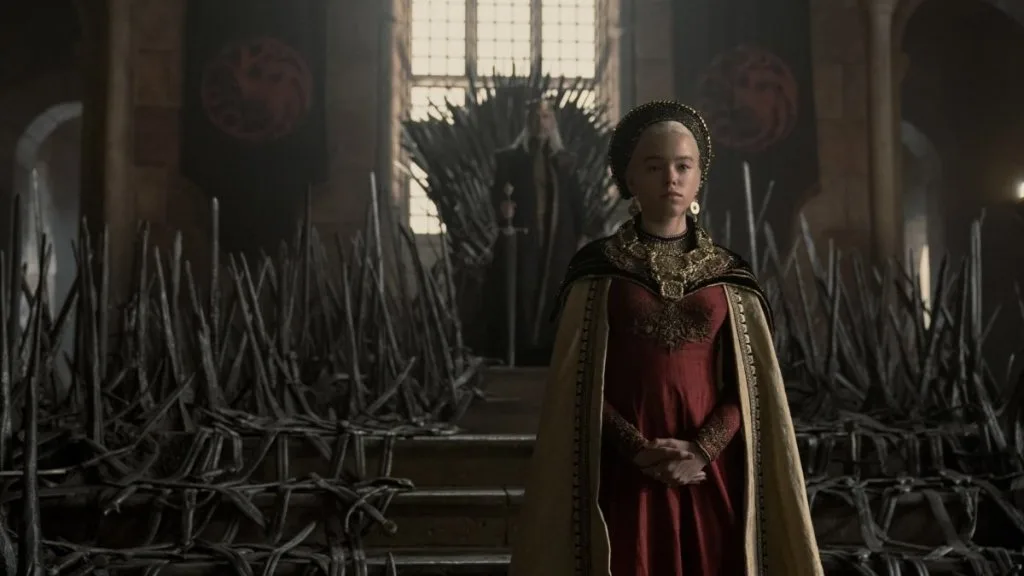 A figure in a red cloak before the Iron Throne.