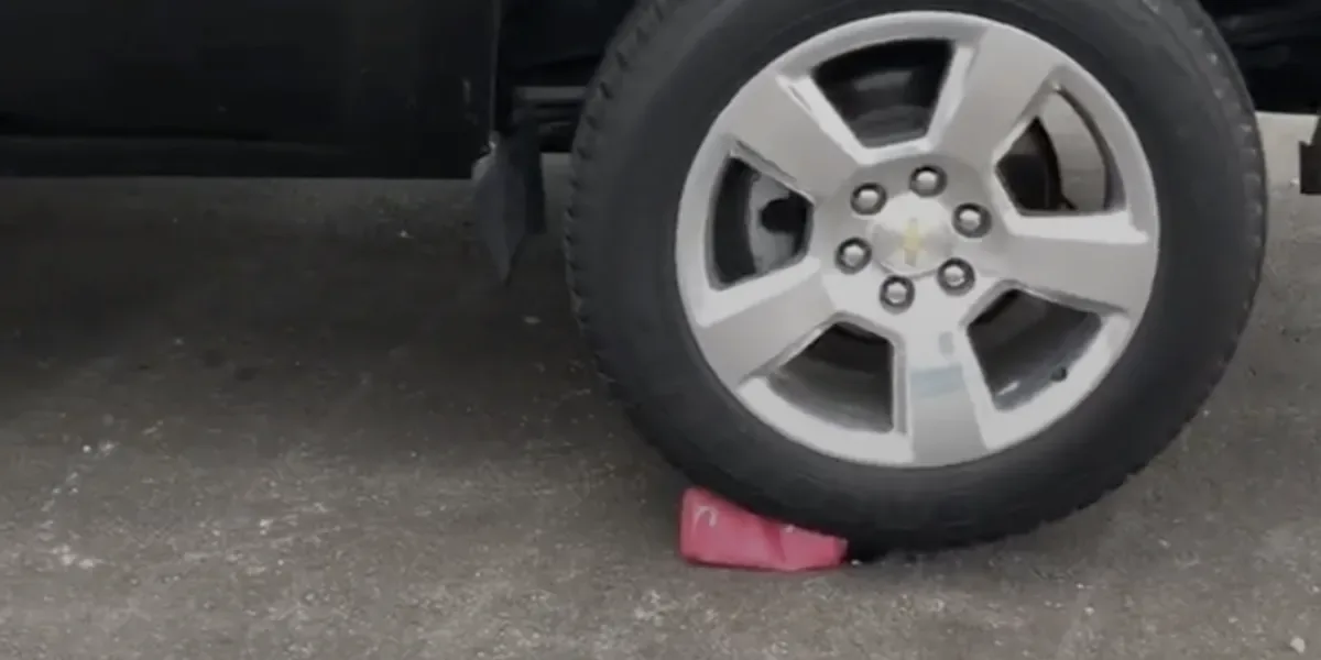 A car tire about to crush a Hydro Flask