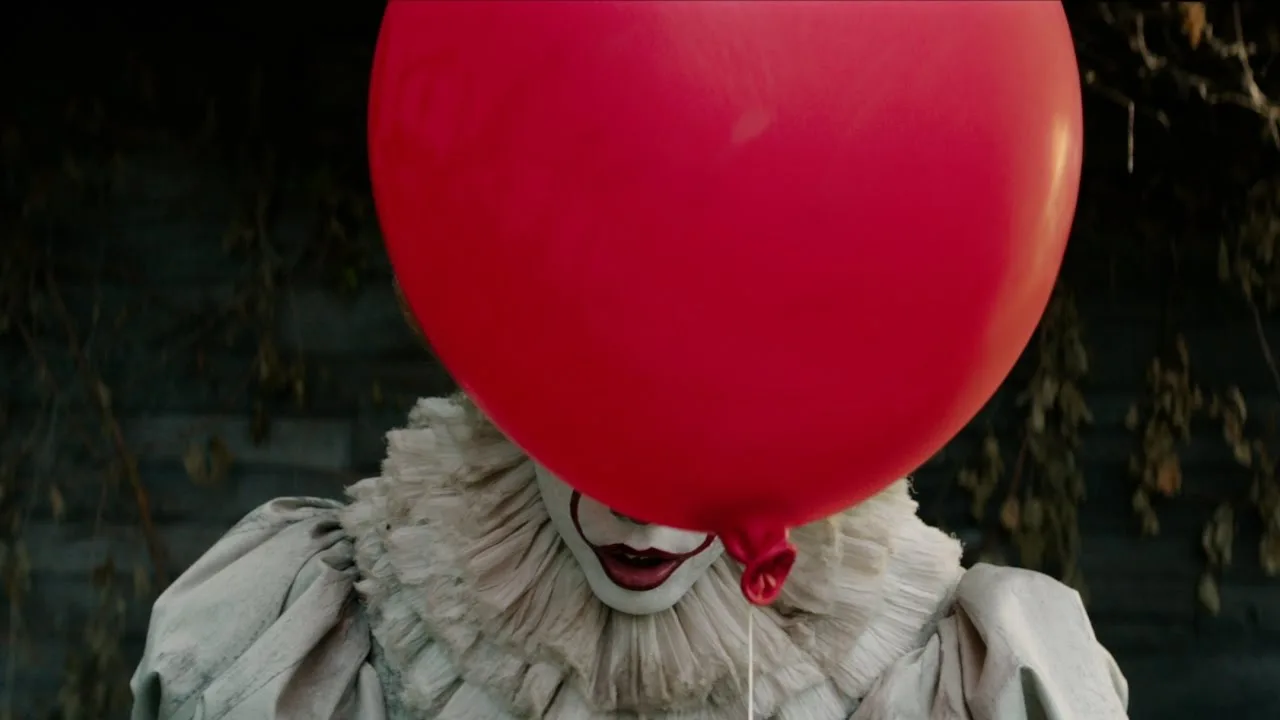 Pennywise behind a red balloon in the teaser trailer.