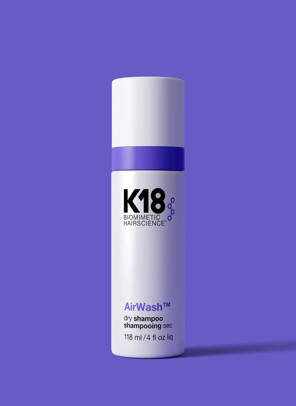 K18 AirWash dry shampoo bottle against a purple background.