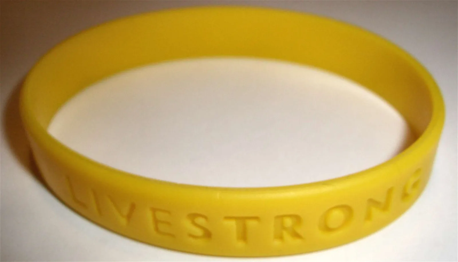 Yellow Livestrong wristband on white paper; Sherool, CC BY-SA 3.0.