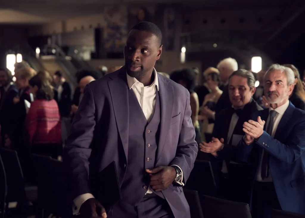 Omar Sy as Assane Diop at an auction in Lupin