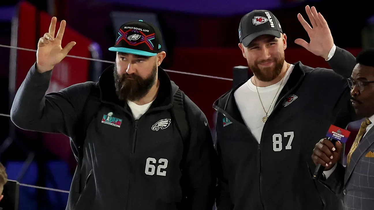 Brothers Jason Kelce of the Philadelphia Eagles and Travis Kelcebof the Kansas City Chiefs wave onstage during Super Bowl LVII Opening Night presented by Fast Twitch at Footprint Center on February…