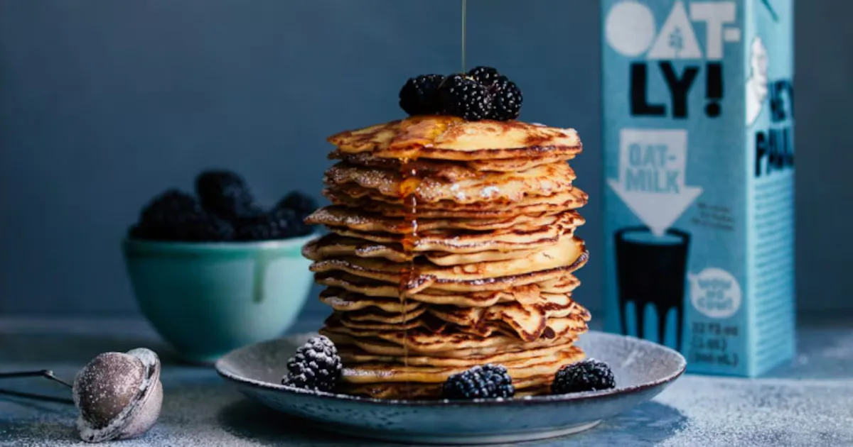 Oatly carton beside a stack of pancakes