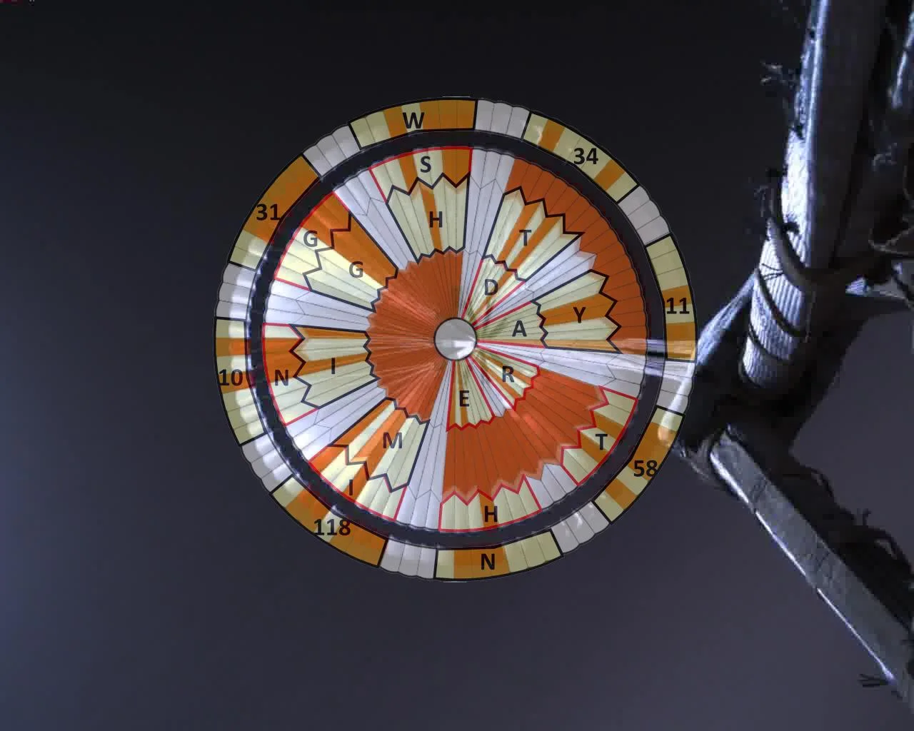 NASA’s annotated parachute decoder: motto in the inner rings and JPL coordinates outside.