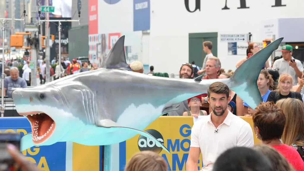 Michael Phelps beside a giant shark model in New York