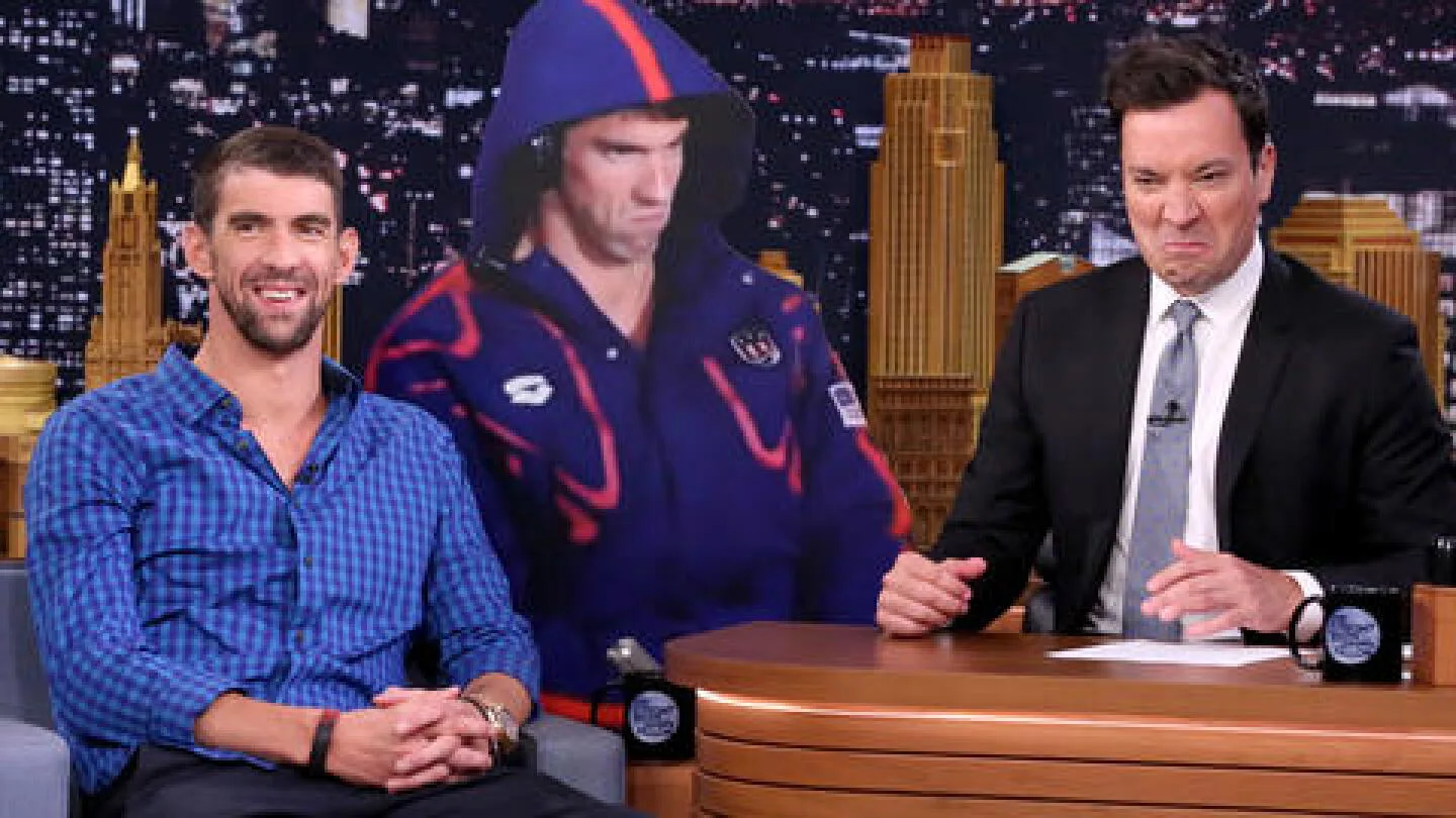 Michael Phelps and Jimmy Fallon beside a life-size PhelpsFace cutout on The Tonight Show.