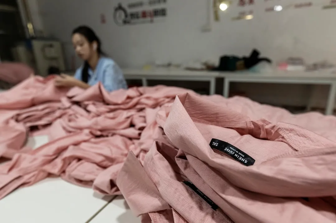 A worker sorts pink garments in a Shein supplier workshop