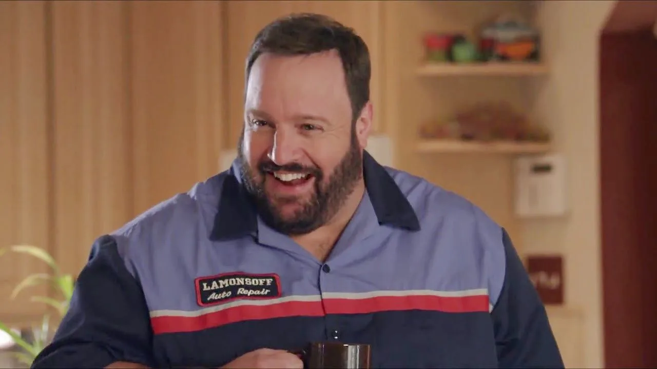 Kevin James in a work shirt and with beared, starring in Grown Ups.