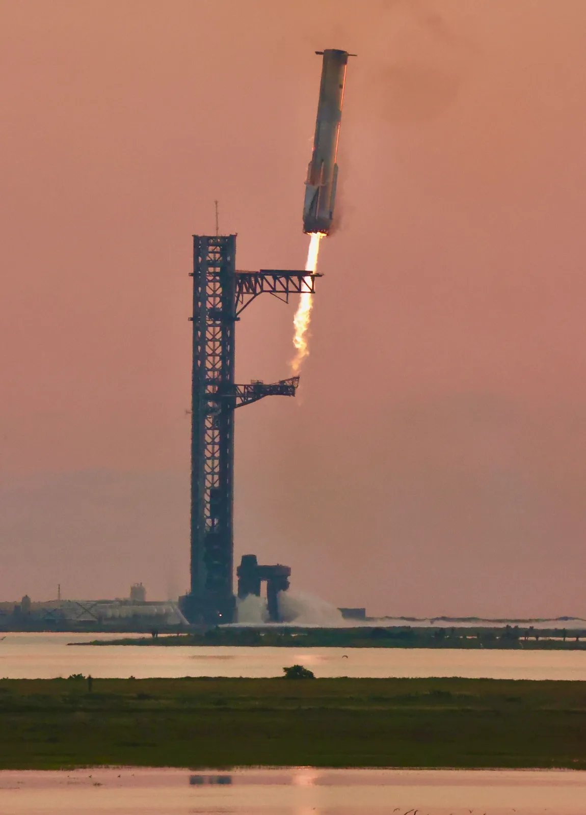 The booster returning to the tower during Starship flight test 5 .