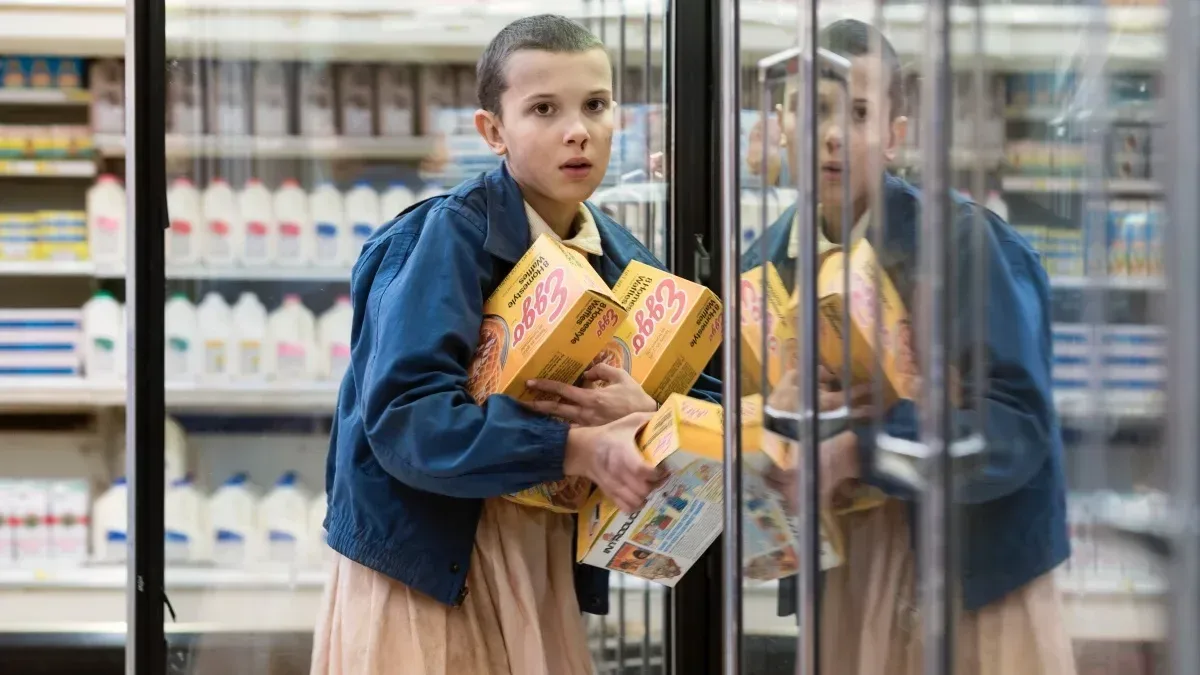 Eleven carrying boxes of Eggo waffles out of a store.