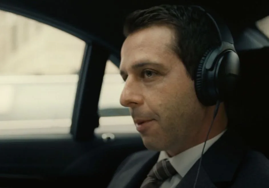 Jeremy Strong as Kendall Roy in a car, wearing headphones