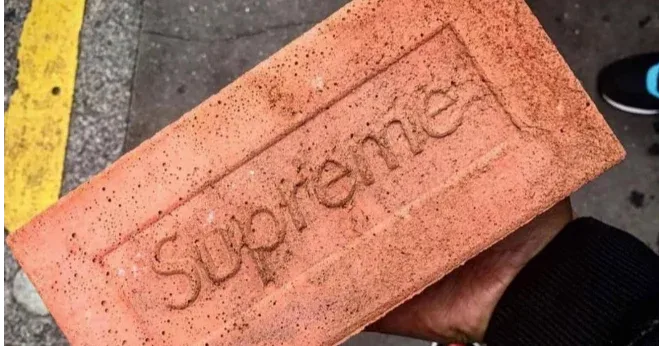 A Supreme brick on pavement