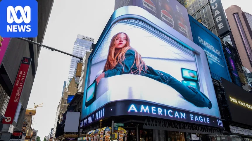A blonde woman wearing denim pictured laying down in a billboard advertisement