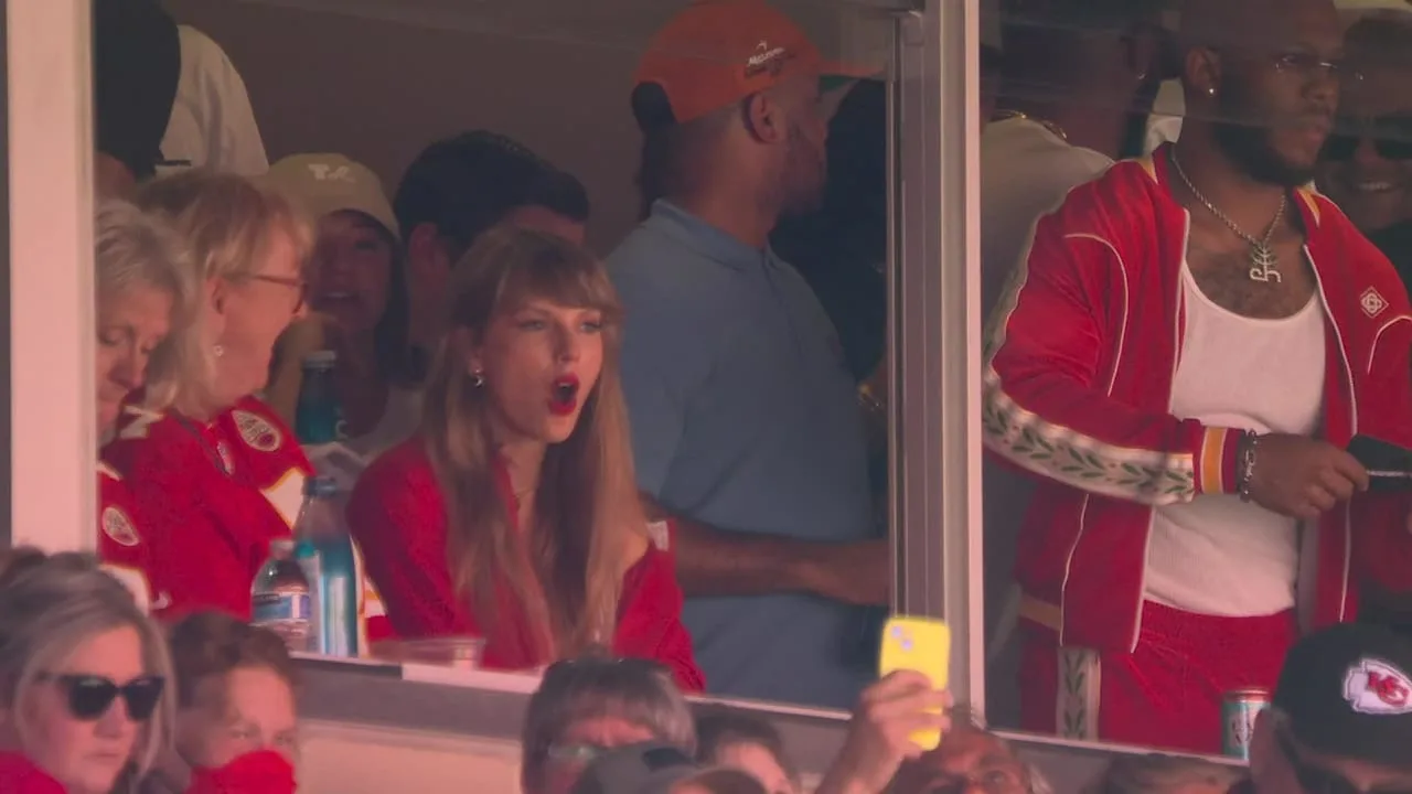Taylor Swift cheers from a suite at her first Chiefs game