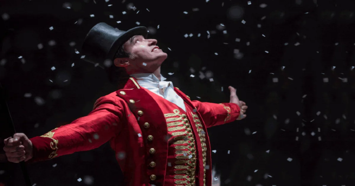 Hugh Jackman as Barnum, arms wide in the ring.