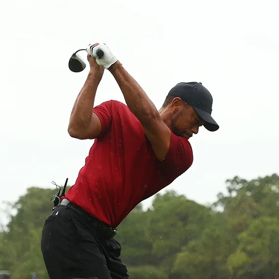 Tiger Woods swinging in a red shirt