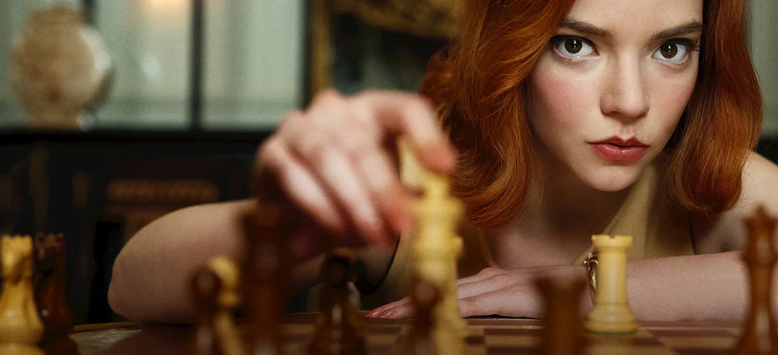 Official Netflix key art showing Beth Harmon reaching across a chessboard.