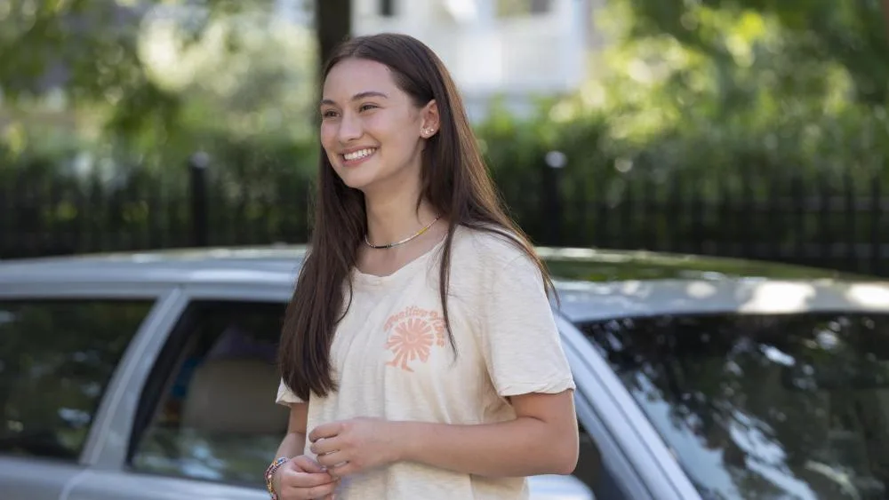 Belly by a car in a scene from the series.