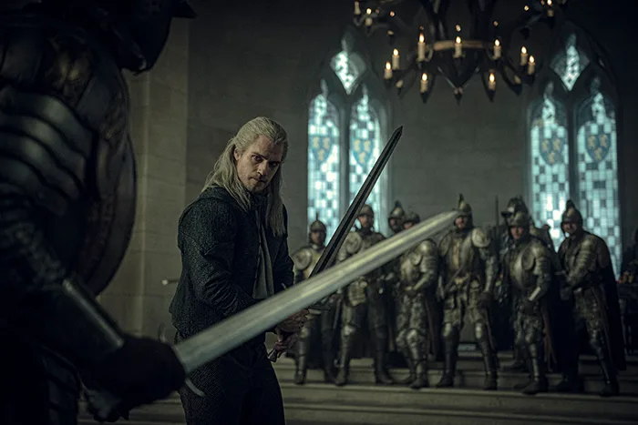 Netflix's first-look image of Geralt in a hall of soldiers