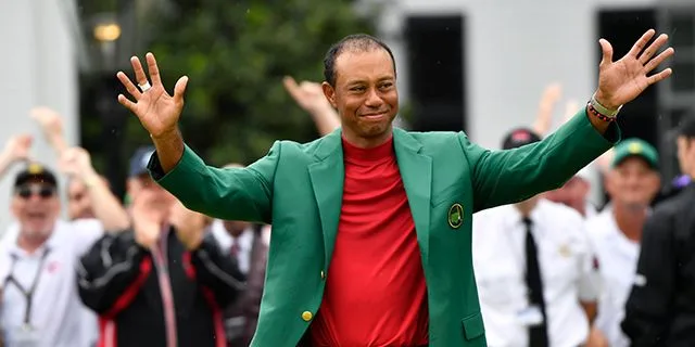 Woods in the green jacket salutes the crowd