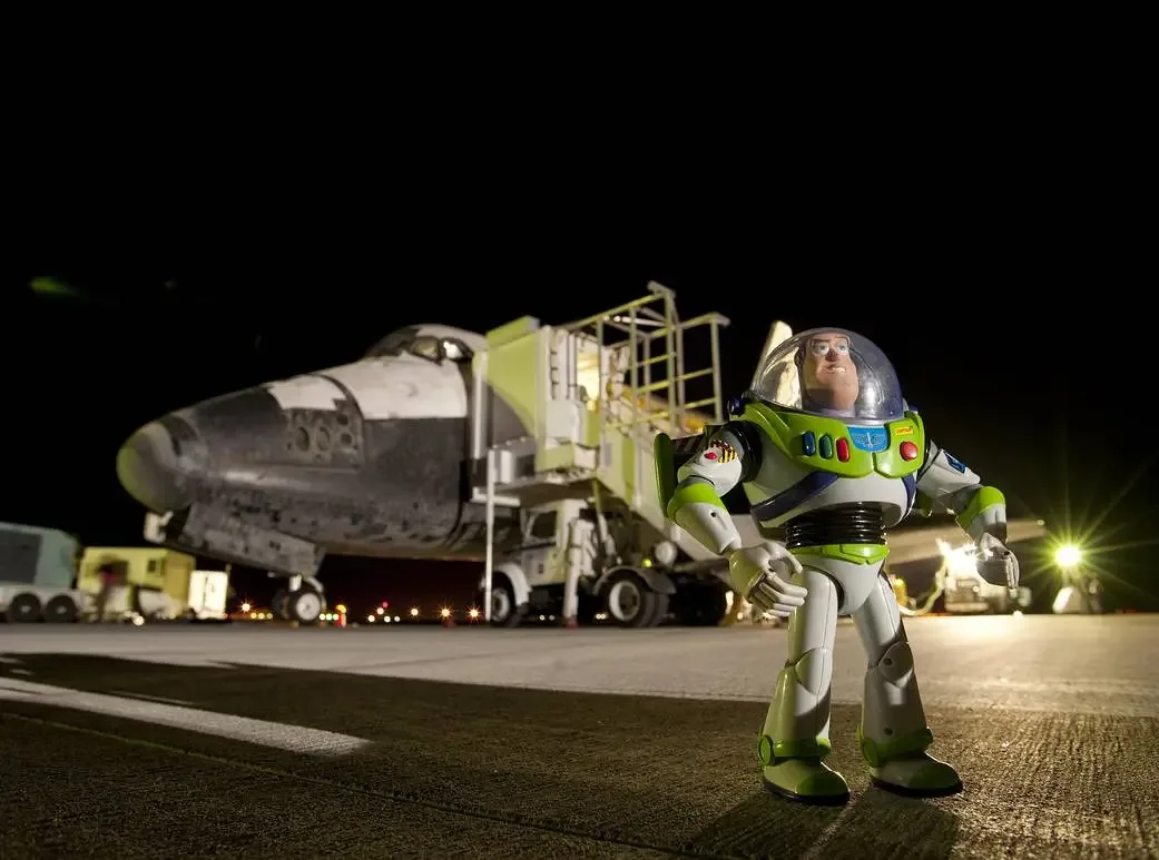 A Buzz Lightyear figure beside the Space Shuttle Discovery after its 2009 return from orbit