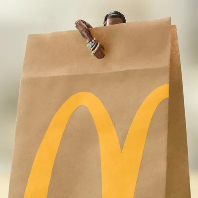McDonald's bag with a miniature Travis Scott figure peeking out, from Wieden+Kennedy's campaign work.